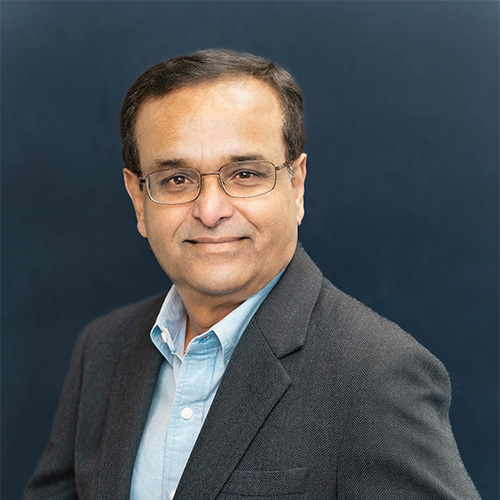 Syed Khan wears a light-blue shirt and gray suit