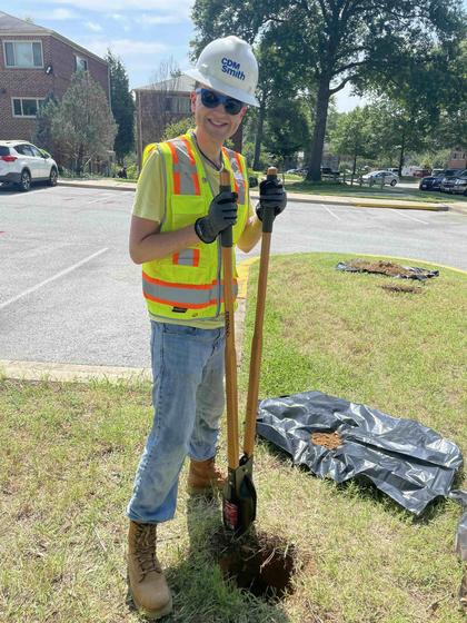 A worker digs a hole in a parking lot median