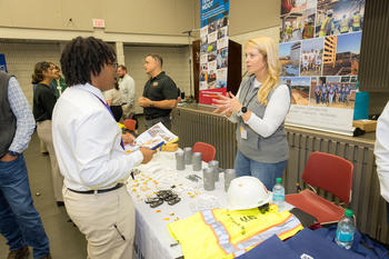 Civil engineering student speaks with prospective employer at 2024 GMU ASCE Career Fair.